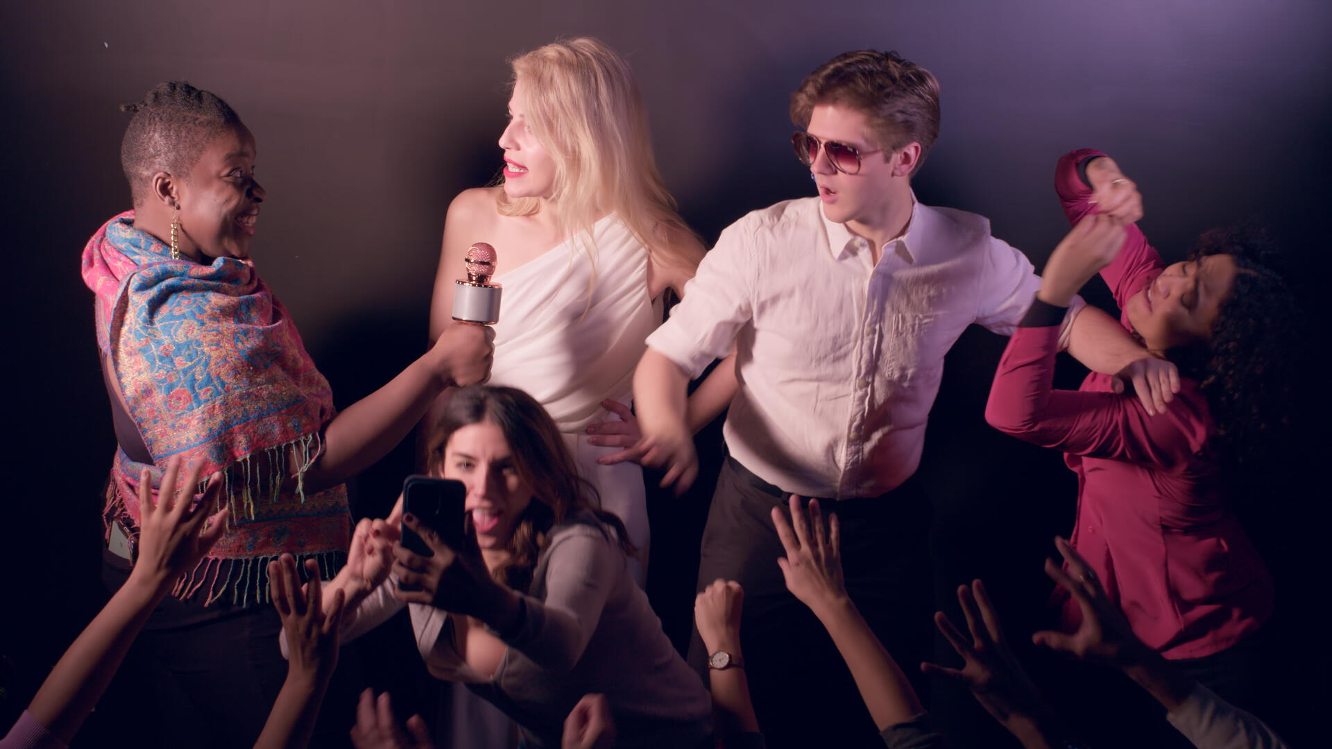 All leads of Late Bloomers stand in a spotlight, dressed to the nines, while fighting off a wave of paparazzi.