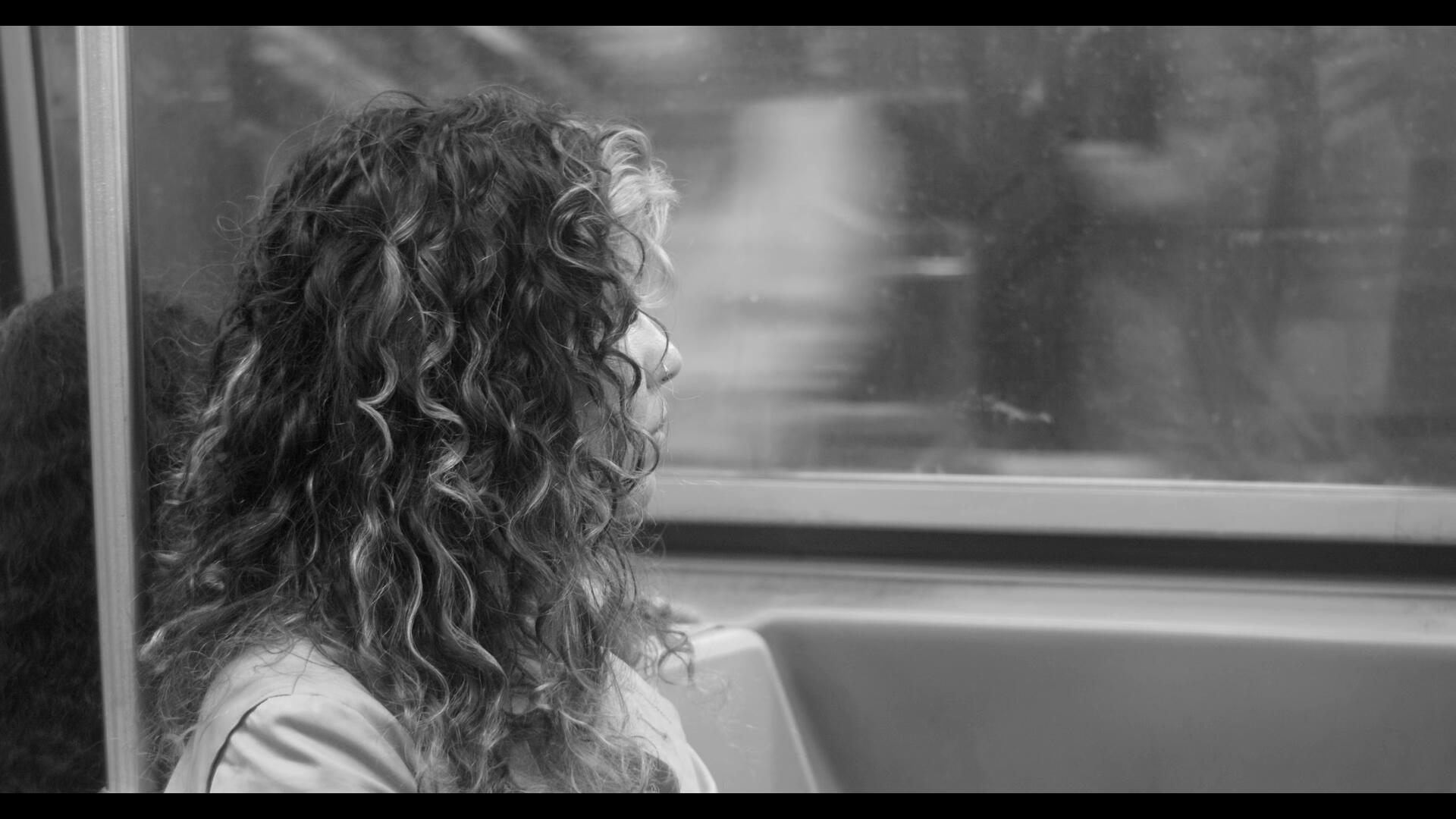 Invited to Leave Patricia sits in the subway, looking longingly out the window.