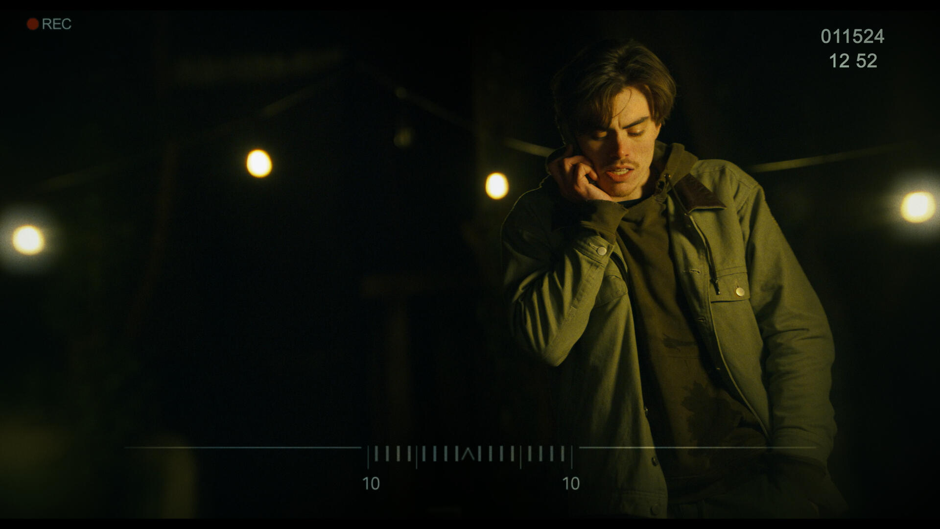 WFTW Still 3 The antagonist of Working for the Weekend, as scene through a set of binoculars in a dark yard. It's lit by several warmly lit bulbs on a string.